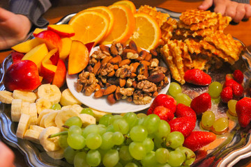 Plate for fondue. Plate with sliced fruit and nuts for fondue.