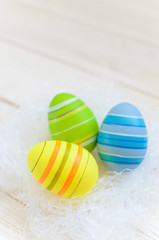 Beautiful bright postcard (background) for a light Easter holiday - three multicolored easter easter eggs