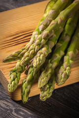 Fresh green asparagus on dark wooden table.