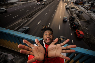 Top view of afro-amercan man rising his hands up and screaming
