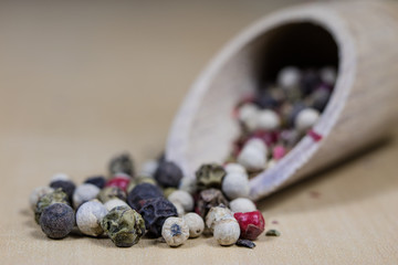 A grain of pepper on a kitchen table. Ground pepper in a kitchen mill.