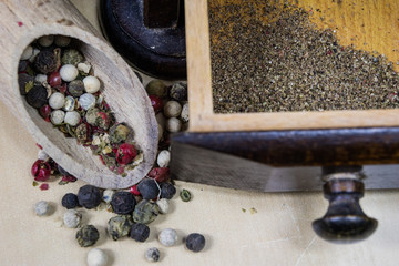 A grain of pepper on a kitchen table. Ground pepper in a kitchen mill.