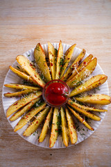Garlic baked potato wedges with paprika and parmesan cheese. Potato fries on white plate