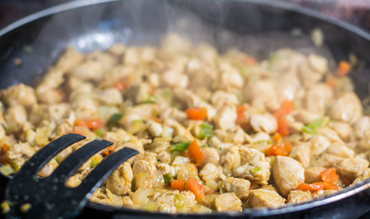 Cooking burrito in a pan with chicken, pepper, tomato for fajitas typical Latin America food