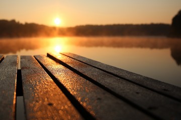 Photo taken early in the morning on the shore of the lake. The bridge after the night is still wet.
