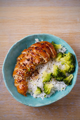 Glased chicken breast, rice and broccoli as garnish. Chicken in balsamic vinegar and brown sugar sauce