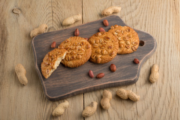 Fototapeta premium Peanut biscuits with nuts and cocoa powder. Top view, on a wooden texture