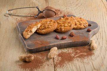 Peanut biscuits with nuts and cocoa powder. Top view, on a wooden texture