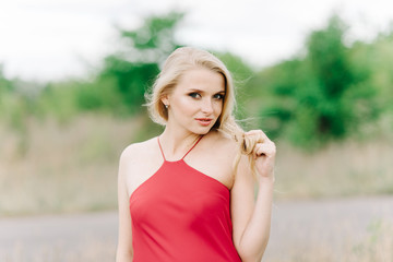 young girl with white hair on a green background in a red dress