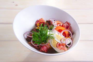 Country salad with fried potato, bacon, brown bread chips, egg, tomato and onion