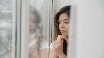 teenage leisure. dreamy romantic young girl sitting on the windowsill and looking out of the window