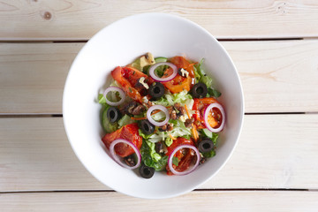 Salad with fried tomato, walnuts, cucumber, onion and olives