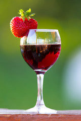 A glass of wine with strawberries outdoors