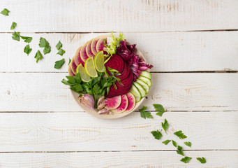 Fresh salad with beets, watermelon radish, cucumber, parsley, lime, garlic, olive oil, mix salads. Healthy concept. White background. Flat lay. Top view.	
