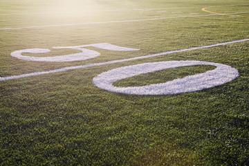 Fifty yard line on green football field