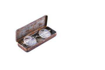 Antique round spectacles 1920s lie in the iron rusty case, isolated on white background, place for text, design object