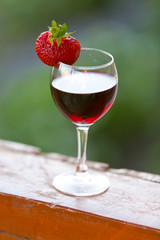 A glass of wine with strawberries outdoors