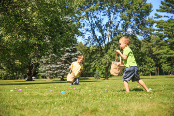 children hunt for Easter eggs. happy kids pick up colorful eggs. the concept of Easter Egg Hunt....