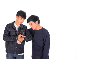 Two Thai boys in jeans jacket are looking at the watch.