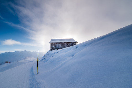 Cottage on the top of a mountain in the alps during winter