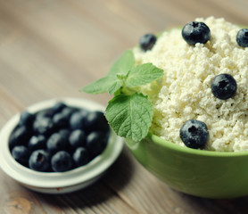 Cottage cheese and blueberry in a bowl on a table. Good breakfast