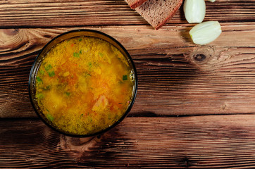 Vegetable soup in a glass bowl on wooden table. Top view