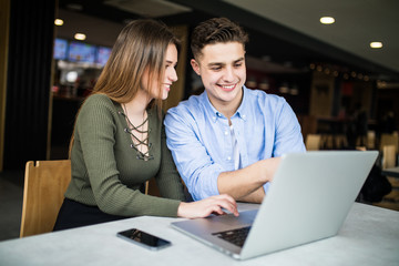 Fototapeta premium Young couple is working in cafe on laptop