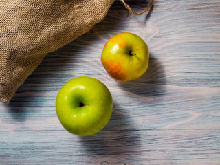 Ripe green and red-green apples on wooden background