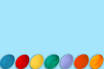 Happy Easter card. Colorful shiny easter eggs on blue background. Copy space for text.