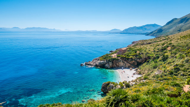 The perfect secret beach: white pebbles beach and turquoise sea, surrounded by luxuriant vegetation of the natural reserve &ldquo;Riserva dello Zingaro&rdquo;, San Vito Lo Capo, Sicily, Mediterranean Sea, Italy.
