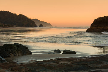 Beautiful Sunset at Cannon Beach, Oregon. The popular resort areas of Cannon Beach and Arch Cape provide a scenic background for a stroll on soft white sand beach.