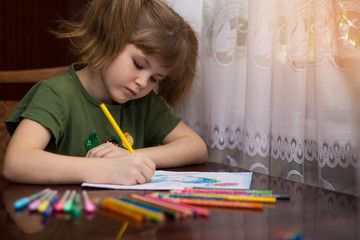 Cute little kid girl drawing by multi-colored pencils. concept of kids hobby or childhood, happy lifestyle