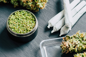 Macro of marijuana with trichomes and crushed weed and rolled joint The concept of marijuana...
