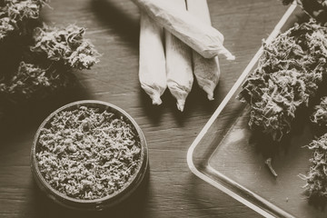 Macro of marijuana with trichomes and crushed weed and rolled joint Vintage color