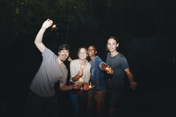 Friends having fun with sparklers in the night