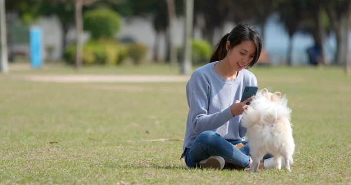 Woman taking photo on her dog with cellphone