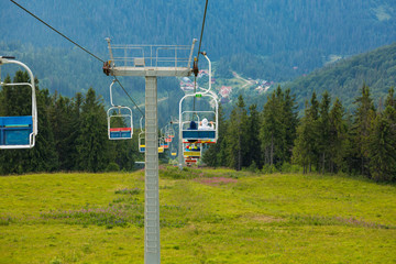 ski lift somewhere very high in the mountains with open chairs and with amazing summer view 