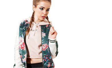 Portrait of a fashion beautiful model in a bomb jacket with floral print standing on a white...
