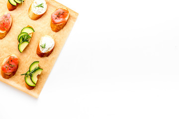 Mini sandwich set with french baguette, cheese, fish and avocado on white background top view mock up