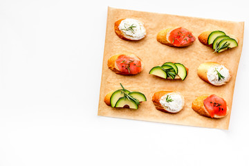homemade sandwiches with french baguette, salmon, cheese and vegetable on white background top view mock-up