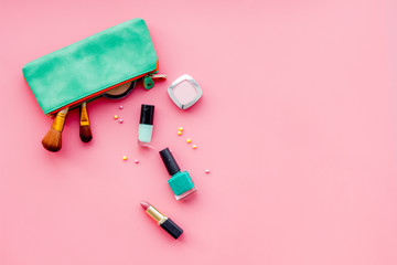 Women desk with decorative cosmetics for make up on pink background flat lay space for text