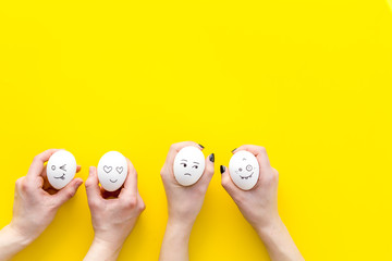 Fototapeta na wymiar Emotions in communication at social media. Faces drawn on eggs. Happy, smile, sad, angry, in love, saticfied, laughing. Yellow background top view copy space