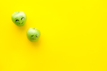 Basic emotions concept. Faces drawn on apples. Happy, smile, sad, angry, in love. Yellow background top view copy space