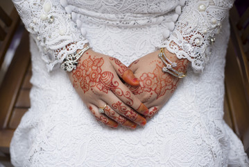 bridal hand with henna paintings and gold bracelets