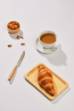 Breakfast with croissant and black coffee composition.