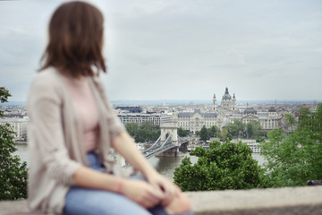 Young girl tourist from behind enjoying sunset looking at view