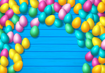 Easter frame with shiny colorful happy eggs spread over wooden background