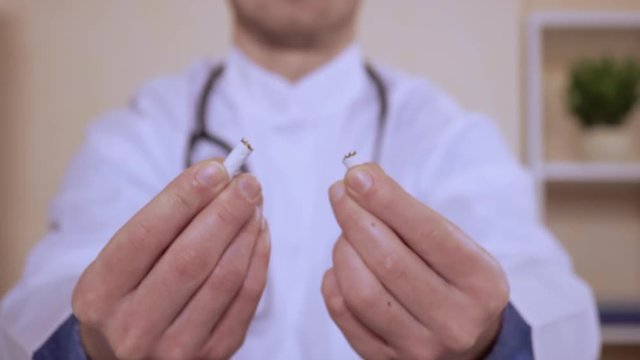 bad habit leading to death unrecognizable doctor holding cigarette and breaks it