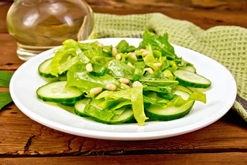 Salad from spinach and cucumber with napkin on board