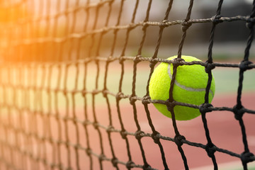 Tennis ball hitting to net on blur tennis court background